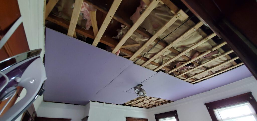 Purple sheet rock being installed in Kitchen ceiling