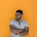 Headshot of founder against bright yellow wall
